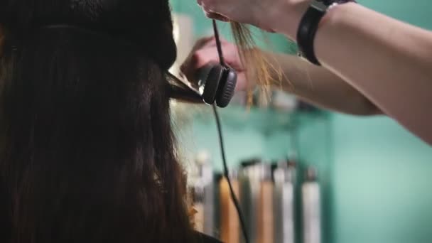 美容師のヘアアイロンでカールを形成美容サロンでクライアントでの作業 - 映像、動画