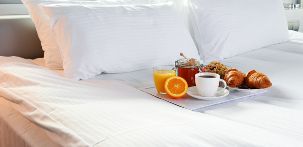 Śniadanie w łóżku w pokoju hotelowym. - Zdjęcie, obraz