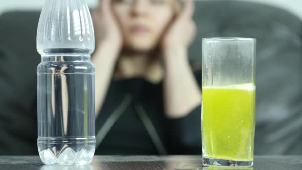 Close-up effervescent tablet in glass of water, stressed depressed suicidal young woman. 4K - Video