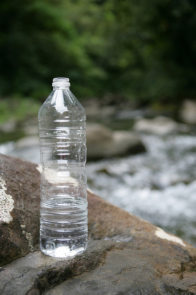 Bottle of water by a stream - Foto, afbeelding