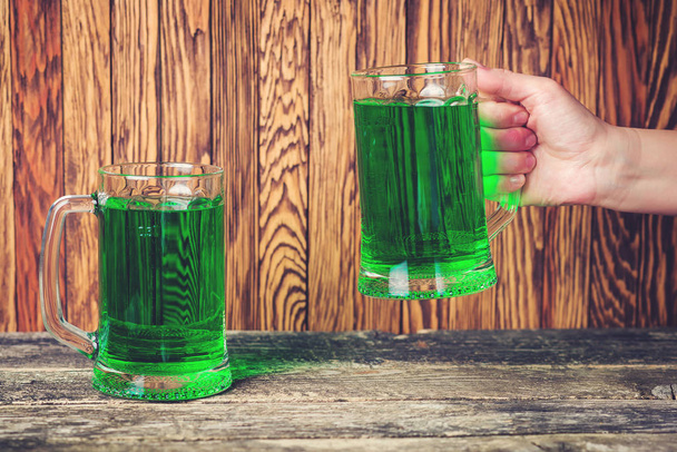 Deux tasses de bière verte sur fond de bois rustique
. - Photo, image