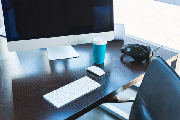 mesa con ordenador, teclado y taza de café en la oficina
 - Foto, Imagen