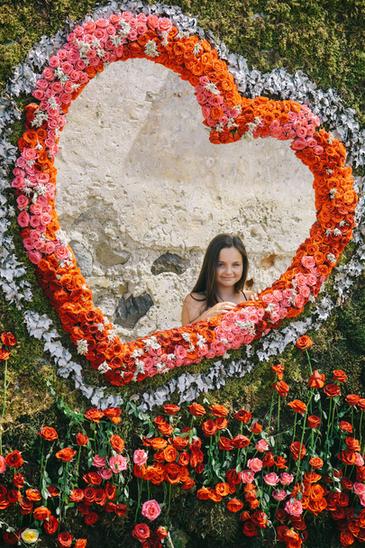 Flower frame in shape of heart with girl smiling inside - Foto, imagen