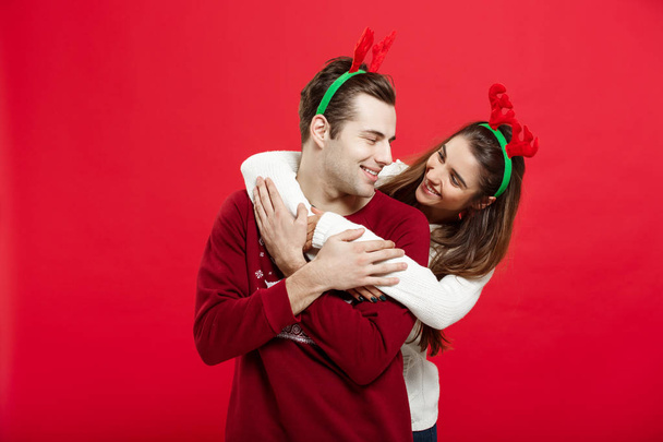 Різдвяна концепція - романтична пара в різдвяних светрах, що обіймають один одного
 - Фото, зображення