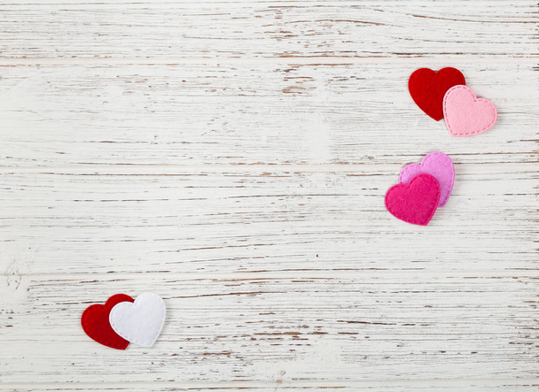 Tarjeta de fondo del día de San Valentín con corazones de tela sobre fondo de madera. Enfoque selectivo
. - Foto, imagen