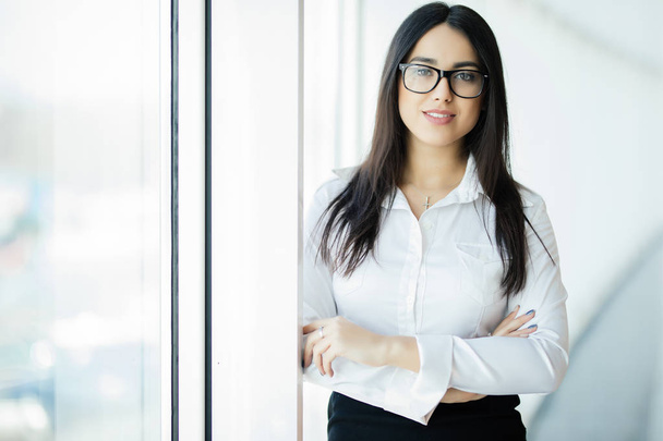 Businesswoman in glasses crossed hands portrait in office with panoramic windows. Business concept - Foto, Imagem