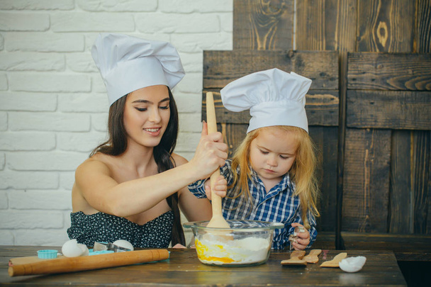 Mother and son mixing flour and eggs in bowl - Fotoğraf, Görsel