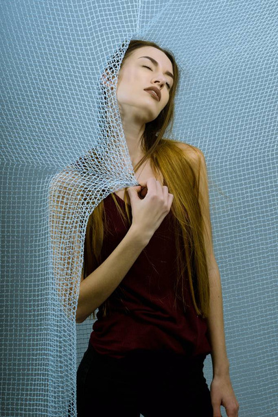 Menina aparência modelo muito bonita em um fundo de rede azul
 - Foto, Imagem