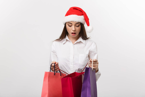 Christmas Concept - beautiful caucasian business woman shocking with gift inside shopping bag. - Foto, imagen