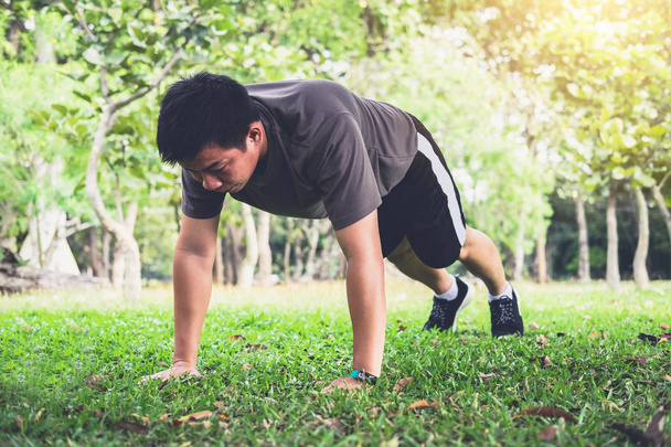 Man push-up exercise workout fitness doing outside on grass  in  - 写真・画像