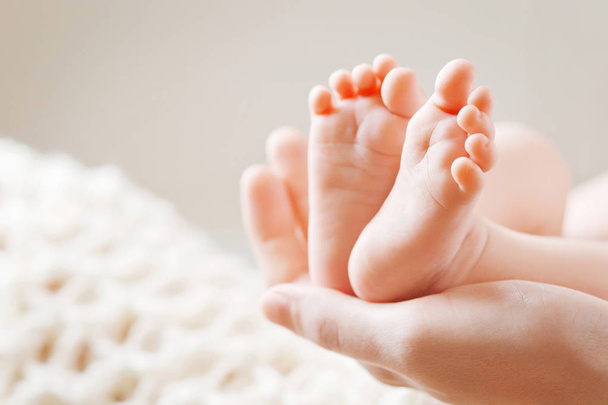 Baby feet in mother hands. Tiny Newborn Baby's feet on female Sh - Zdjęcie, obraz