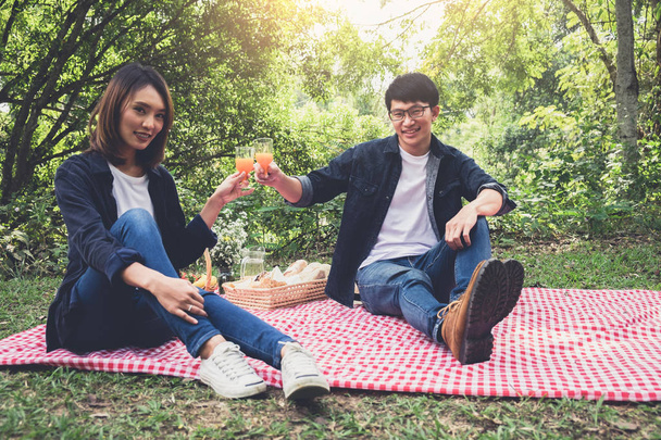 Couple in love drink a orange juice on summer picnic, leisure, h - Foto, afbeelding