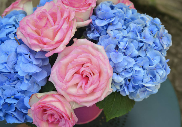 Ramo de rosas rosadas y hortensias azules en un jarrón
 - Foto, imagen