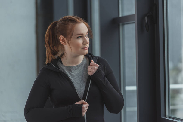 Übergewichtiges Mädchen trägt Sportkleidung im Fitnessstudio - Foto, Bild