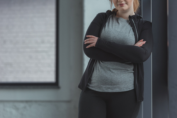 Close-up view of obese girl in gym by window - Photo, Image