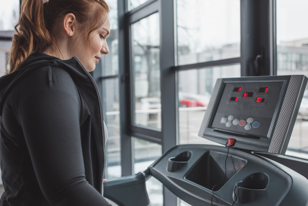 Obese girl running on treadmill in sports center - Fotografie, Obrázek