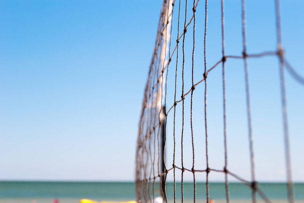 NET do gry w siatkówkę zbliżenie podłączony liny liny na błękitne morze niebieski plaża lato dzień wypoczynek gra sportowa - Zdjęcie, obraz