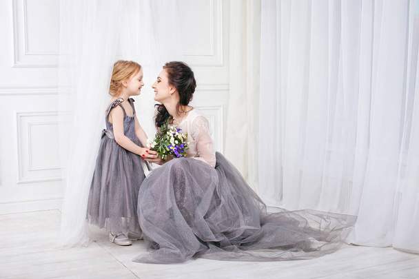 Portrait of mother and daughter in identical dresses.Young mothe - Photo, Image