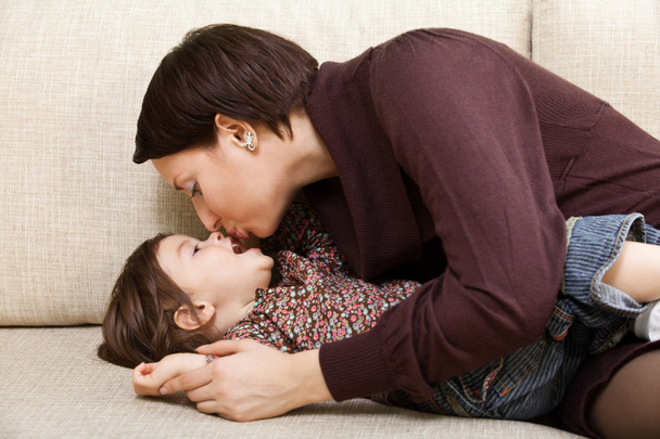 mother kisses daughter - Foto, afbeelding