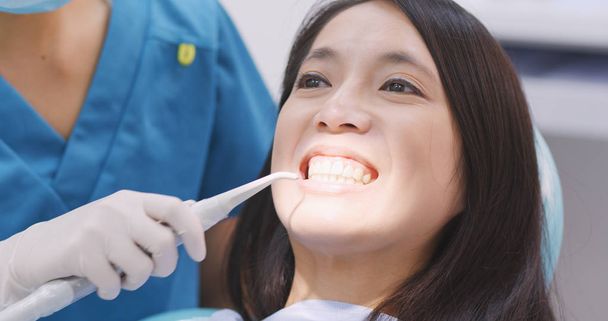 Жінка-стоматолог працює на зубах пацієнтів
  - Фото, зображення