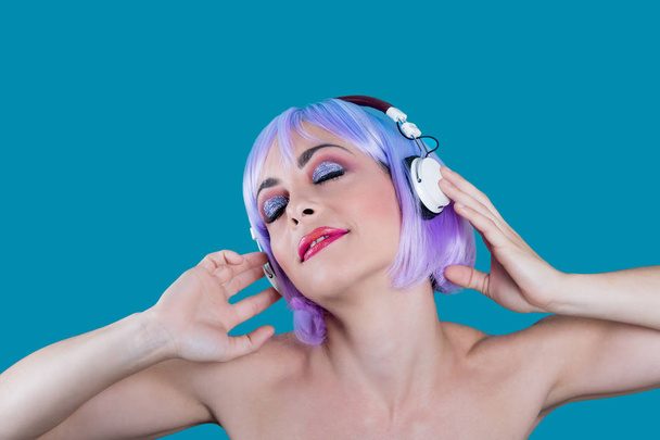 Glamour vrouw luisteren naar muziek in studio - Foto, afbeelding