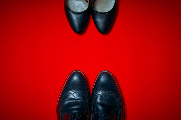 high heels and men's shoes on an intense red background - Photo, Image