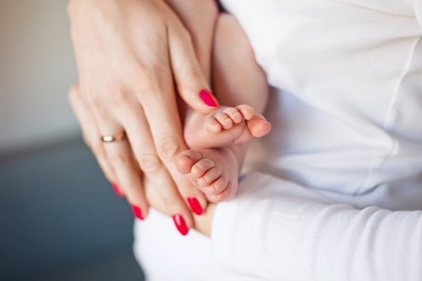 Pieds de bébé entre les mains de la mère. Petit nouveau-né pieds du bébé sur femelle Sh
 - Photo, image