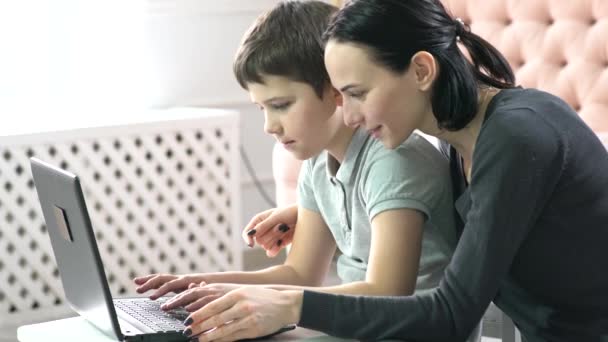 μητέρα και γιος χρησιμοποιώντας φορητό υπολογιστή στο σπίτι. - Πλάνα, βίντεο