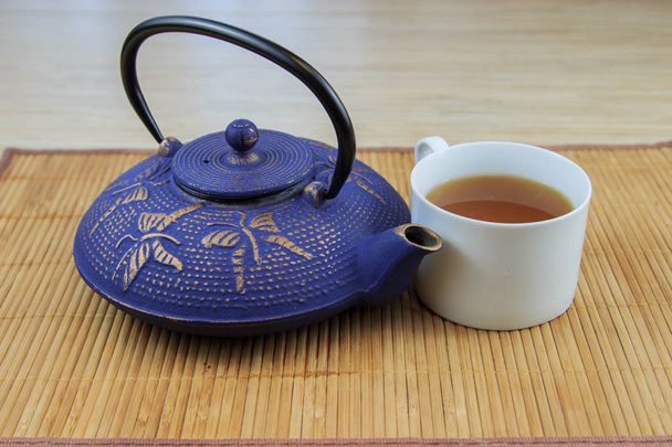 Blue Chinese cast iron teapot. The process of brewing tea.  - Foto, Bild
