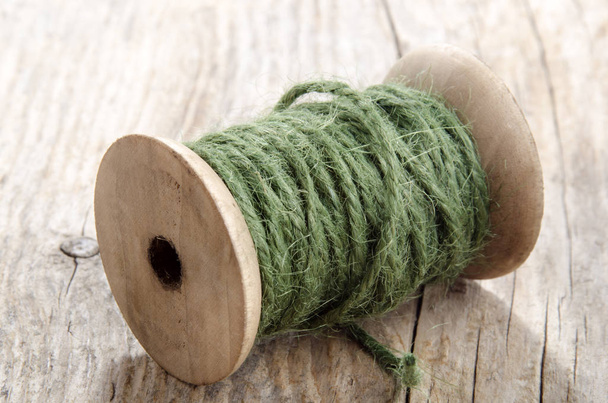 Vintage Wooden Spool With Green Sisal On Rustic Wood close up shot - Foto, Bild
