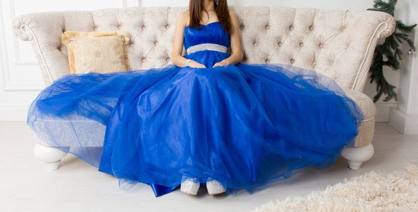 Girl in blue dress on the couch - Fotó, kép