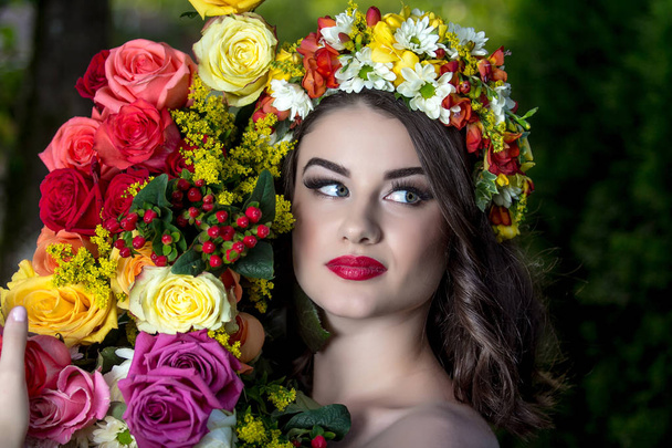 Beautiful woman in a flower wreath a in summer at sunset. - Фото, зображення