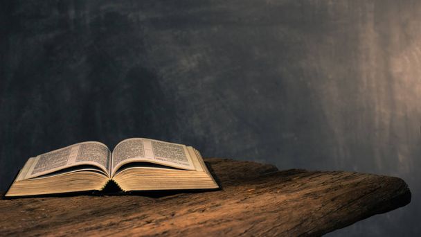 Raamattu krusifiksi ja helmiä vanhan tammen puupöydällä. Kaunis tumma tausta. Uskonto käsite
 - Valokuva, kuva