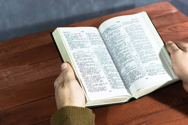 Raamattu punaisella puupöydällä. Kaunis tausta.Uskonnon käsite
 - Valokuva, kuva