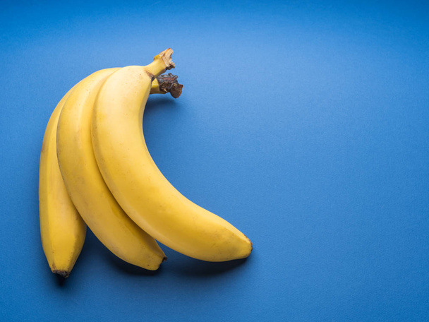 Bananas on the blue background. - Φωτογραφία, εικόνα