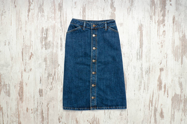 Blue denim skirt. Wooden background, fashionable concept - Photo, Image