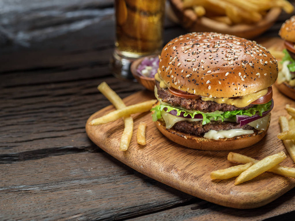 Hamburger and French fries on the wooden tray. - Foto, Bild