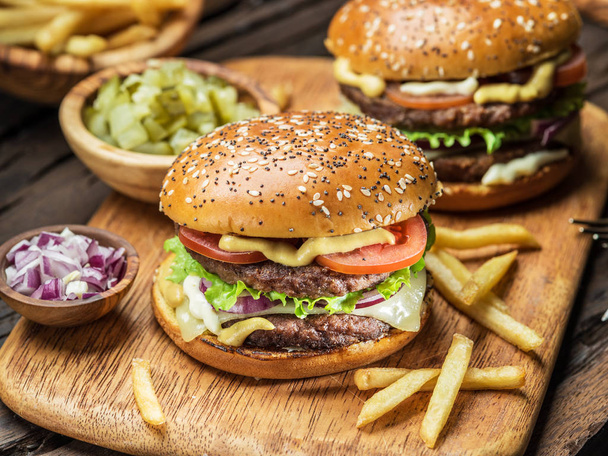 Hamburgers and French fries on the wooden tray. - Φωτογραφία, εικόνα