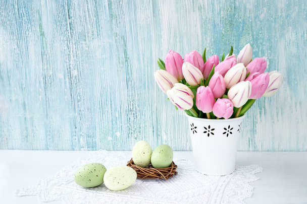 Pasen achtergrond. Decoratieve paaseieren en roze tulpen in witte vaas. Kopiëren van ruimte, Vakantiewoningen achtergrond - Foto, afbeelding