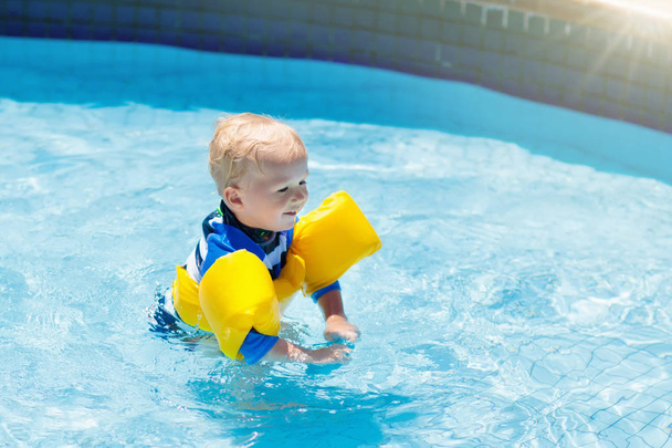 Bambino con bracciali gonfiabili in piscina
.  - Foto, immagini