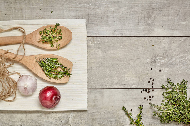 Wooden spoon with Caraway and rosemary, onion, garlic on wooden background. Top view. - Fotoğraf, Görsel