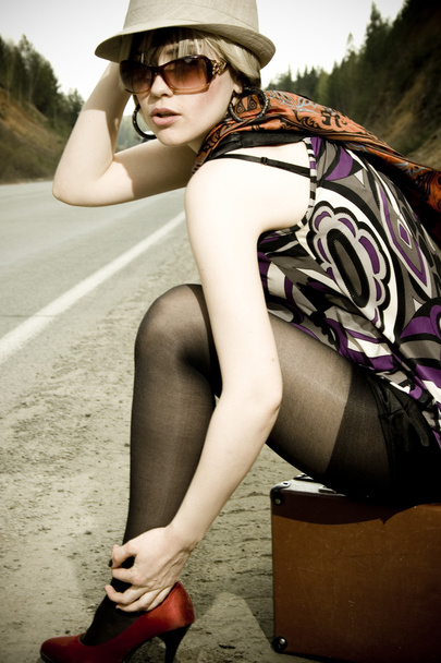 girl hitchhiking with suitcase - Valokuva, kuva