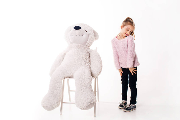 Little girl and a big white teddy bear. Isolated on white background. - Fotografie, Obrázek