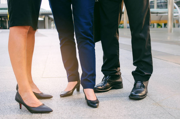 close up legs of group three business people woman and woman team standing at big business district in city together, congratulation, success, meeting, partner, teamwork, community, connection concept - 写真・画像