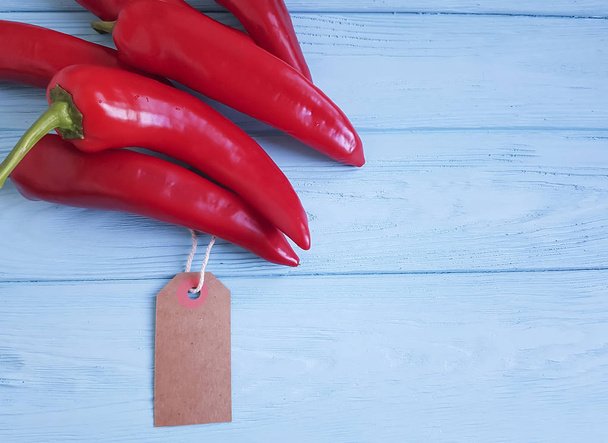 rode peper op blauwe houten tag - Foto, afbeelding