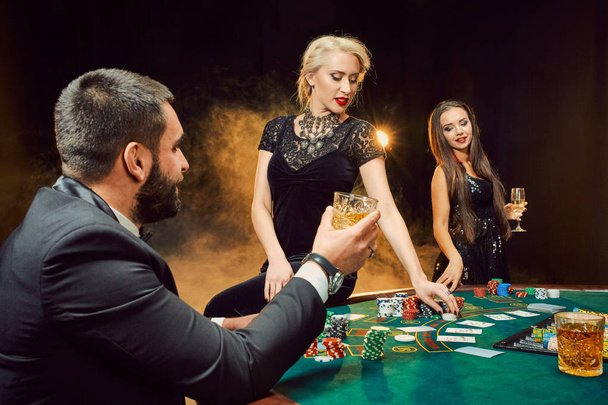 Fiatal gazdagok csoportja pókerezik a kaszinóban. - Fotó, kép