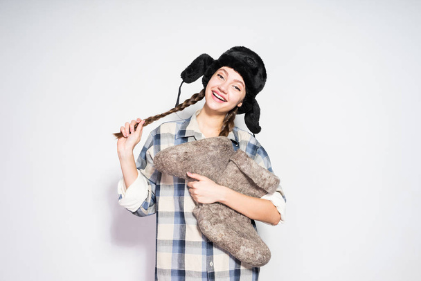 happy beautiful Russian woman in a cap with ear-flaps holds warm winter felt boots - Photo, Image