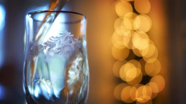 A glass filling up with brandy alchohol with cinematic bokeh in background - Video