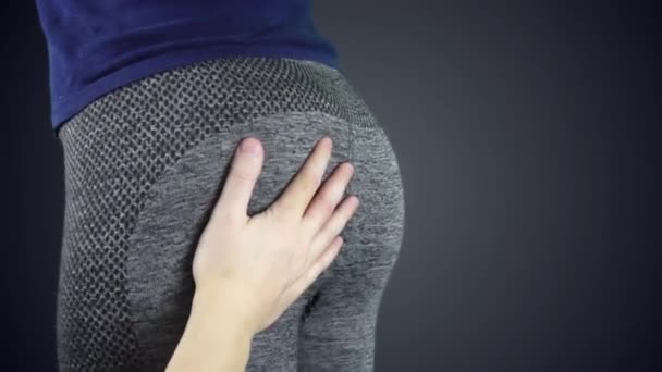 Schlag auf das Gesäß eines Sportlers sexy Mädchen in Strumpfhosen über einem dunklen Hintergrund in Zeitlupe - Filmmaterial, Video