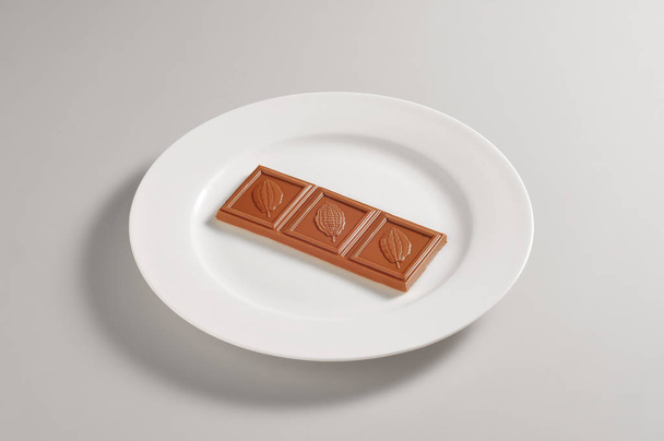 Round plate with milk chocolate bar - Fotoğraf, Görsel